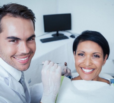 Dentist and patient looking at dental implant model