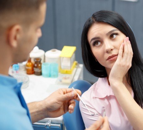 Woman discussing treatment for dental emergency with dentist