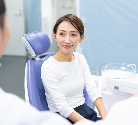 Female patient sitting and smiling at dentist