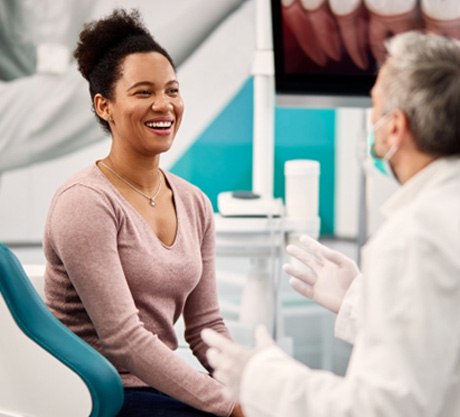 Smiling patient talking to dentist at check-in 