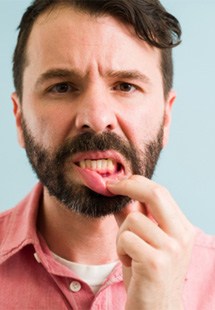 man pointing to inflamed gums 